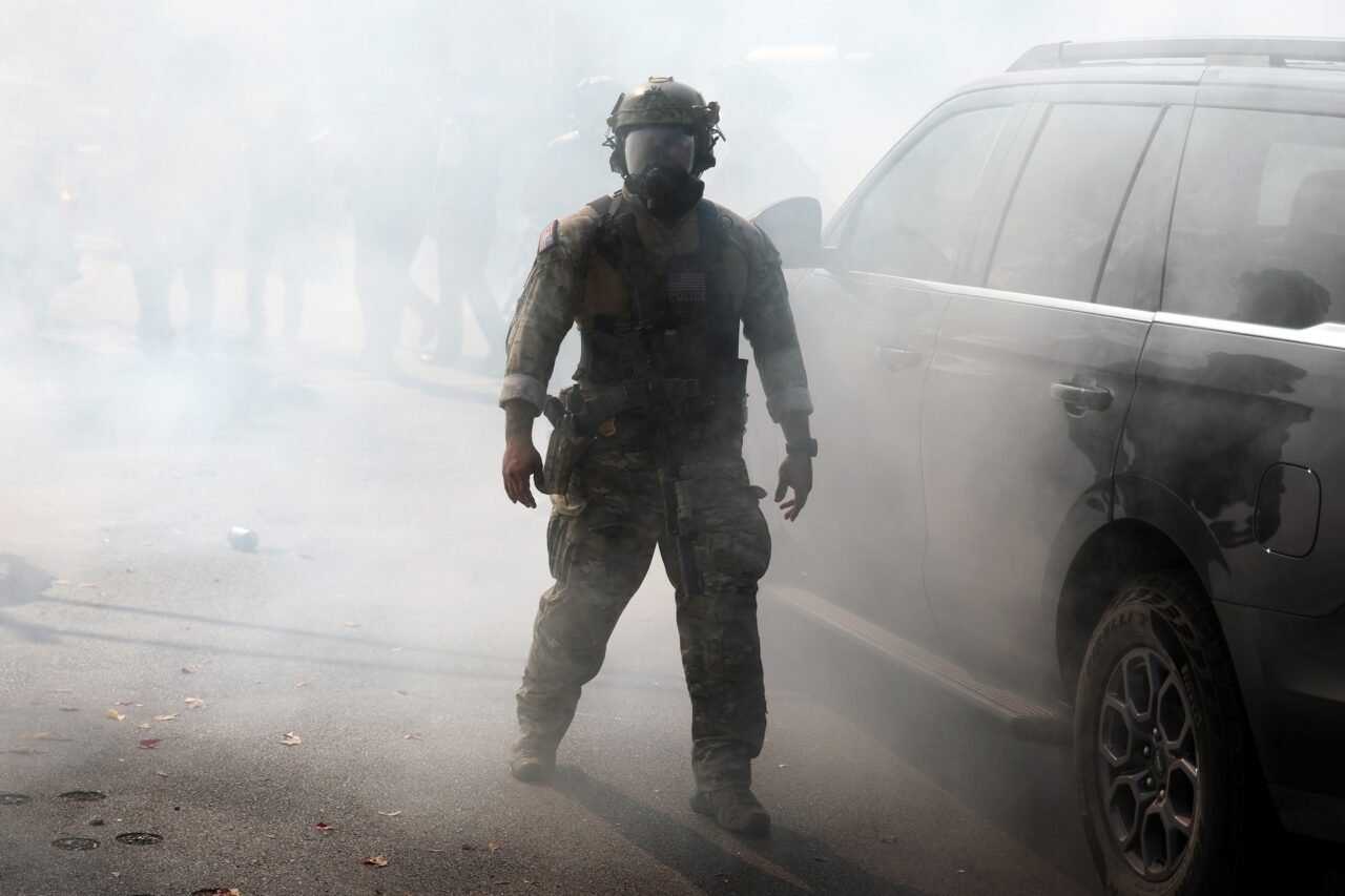 A Border Patrol agent walks through a cloud of tear gas on Tuesday, Oct. 14, 2025, in Chicago.